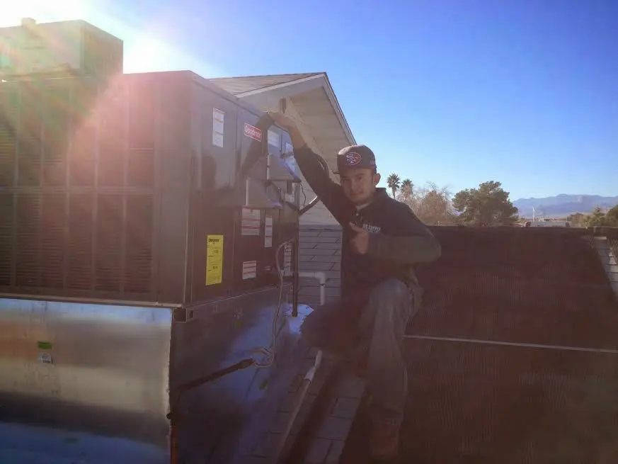 HVAC technician performing AC Tune-Up on a rooftop unit in Kensington